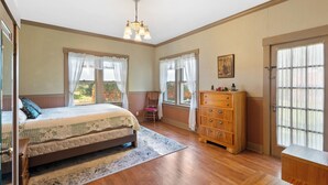 Un dormitorio con cama, cómoda de madera y candelabro.
