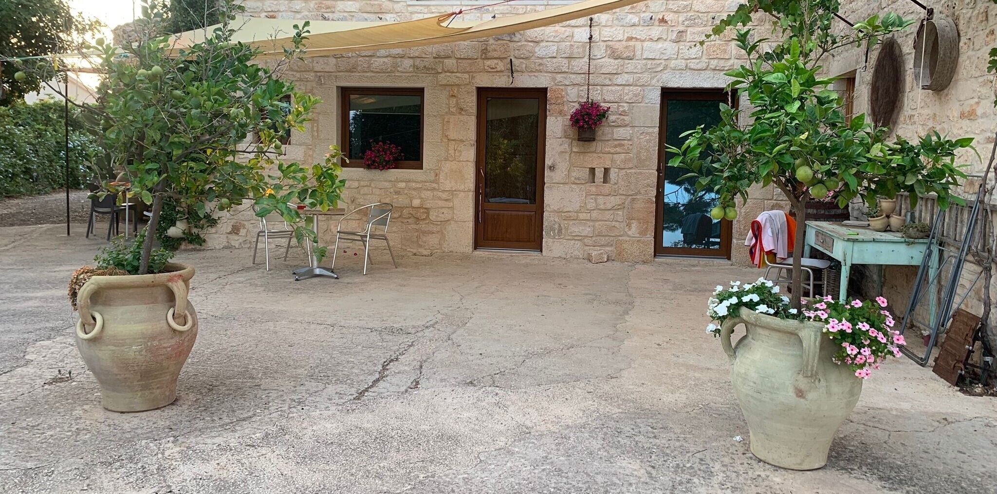 A stone building with a patio, outdoor seating, and potted plants.