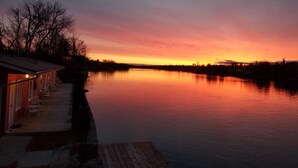 A waterfront property with a dock and a building with outdoor seating. - The Water's Edge Inn (Campbellford)