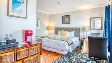A hotel room with a bed, bedside table, lamp, chair, and a coffee machine.