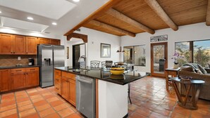 A spacious kitchen with wooden cabinets, stainless steel appliances, and a large island. - Sonoran gem in Hidden Valley with POOL! (Tucson)