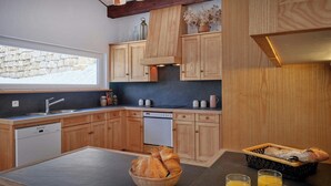 Eine moderne Küche mit Holzausbau, einem eingebauten Geschirrspüler und einer Steinwand.