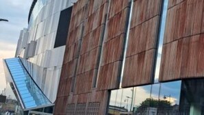 A modern building with a reflective glass facade and wooden paneling. - Bruce Rooms – Your Comfortable Retreat in Tottenham (London)