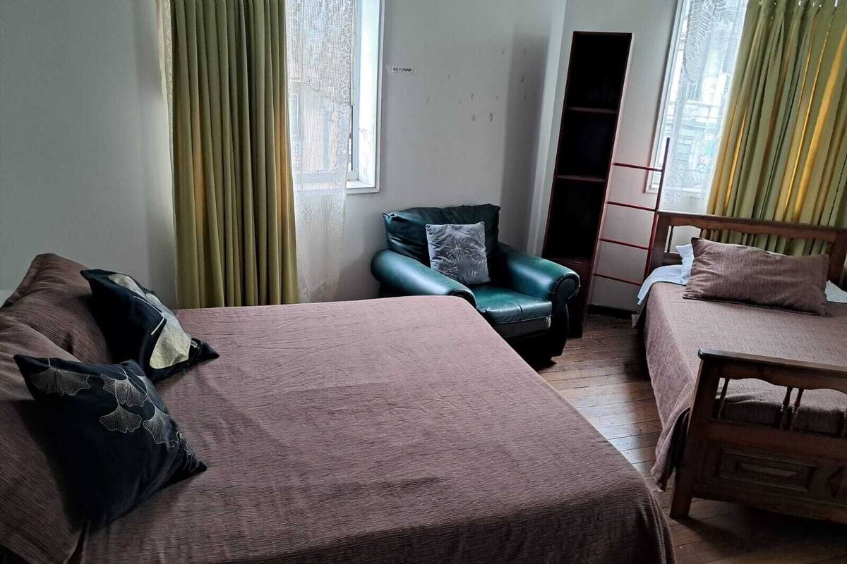 Camera da letto con due letti, una sedia e un armadio.