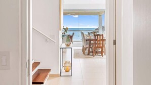 Un couloir menant à une salle à manger avec vue sur la mer.