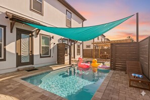 A backyard with a swimming pool, a wooden deck, and a covered patio area. - *New~Heated Pool+Great Patio+Grill+Pool Table (Panama City Beach)