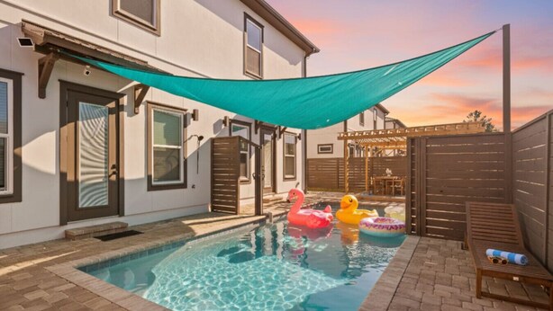 A backyard with a swimming pool, a wooden deck, and a covered patio area. - Vincente Seascape (A) (Panama City Beach)