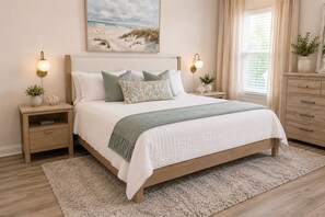 Ein Schlafzimmer mit Bett, Nachttischen, Kommode, einem Gemälde und einem Fenster mit Vorhängen.