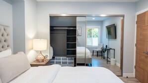 A bedroom with a bed, bedside lamp, and a closet with a mirror. - UPSCALE & UPGRADED 3BR HOUSE in ENCINO with GARAGE & LARGE FENCED YARD/PATIO p84 (Los Angeles)