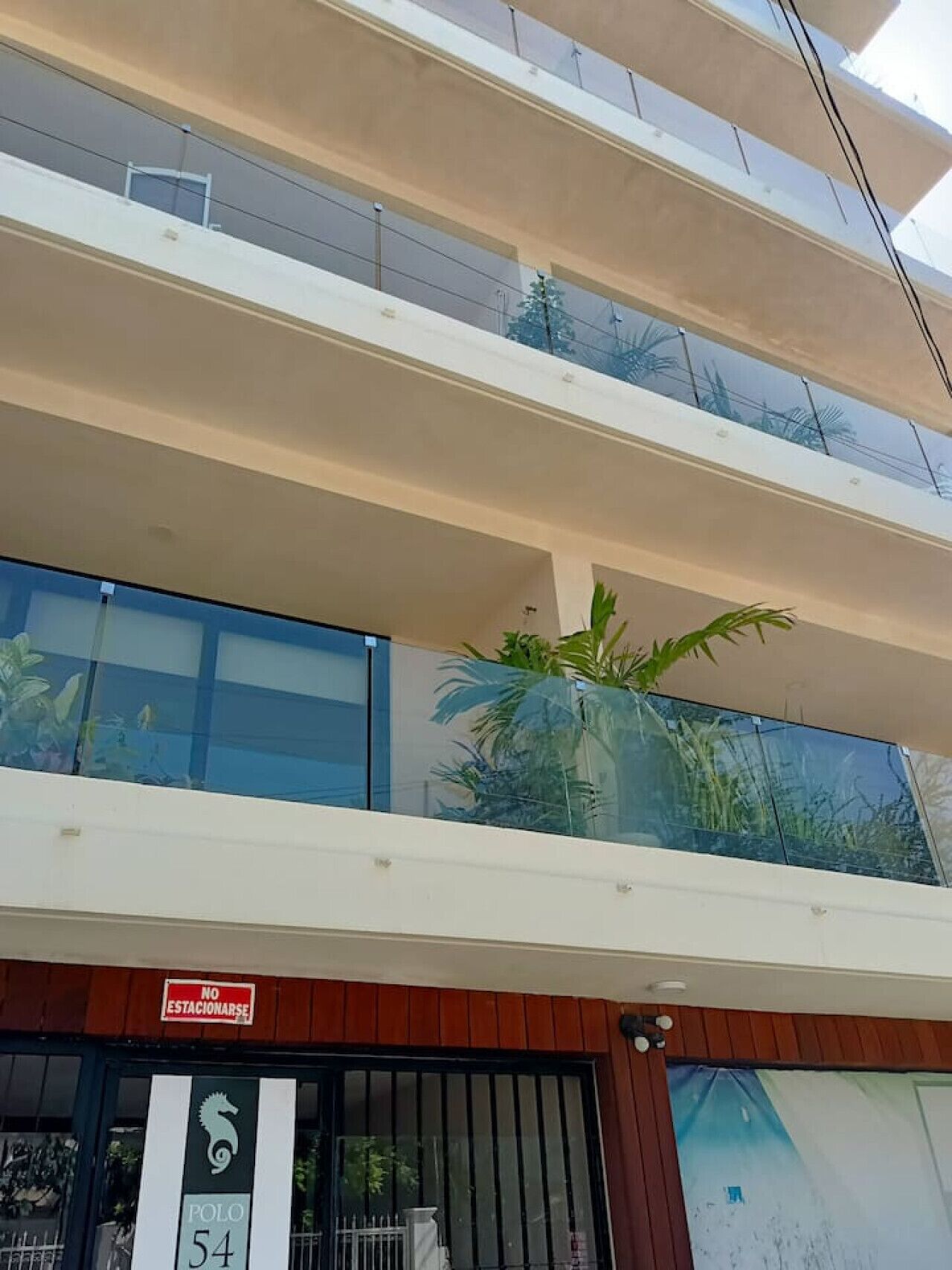 A multi-story building with a ground-floor entrance marked by a sign.