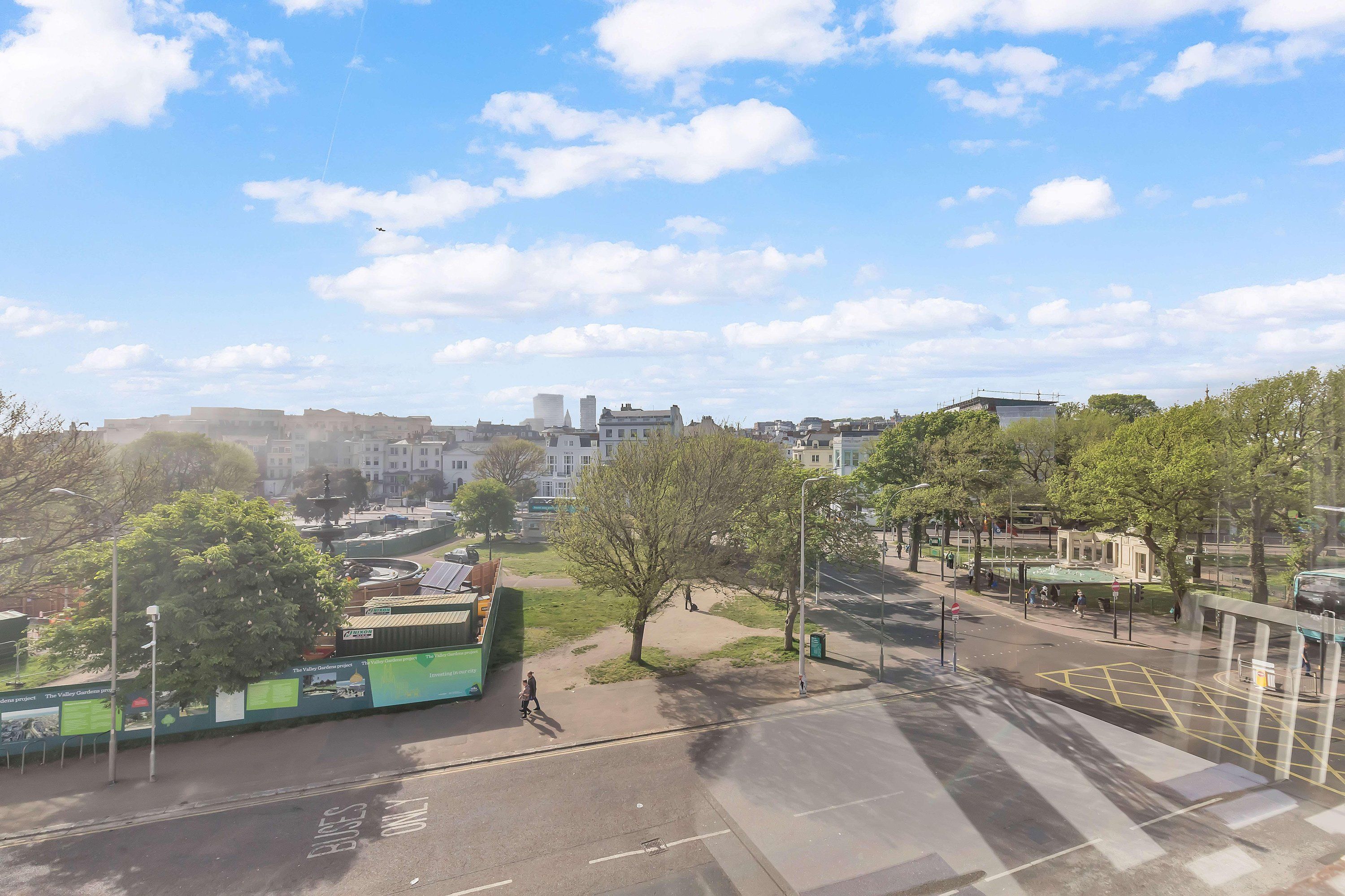 Un paysage urbain avec des bâtiments, des arbres et un ciel dégagé.