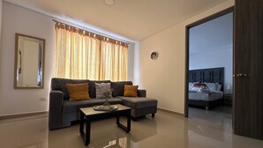 A modern living room with a sofa, a coffee table, and a large mirror. - Nirvana ApartaHotel (Cali)