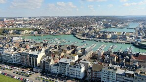A coastal cityscape with a marina filled with boats, historic buildings, and modern architecture. - Entre Port & Mer - Spacious 77m2 apartment in Dieppe (Dieppe)
