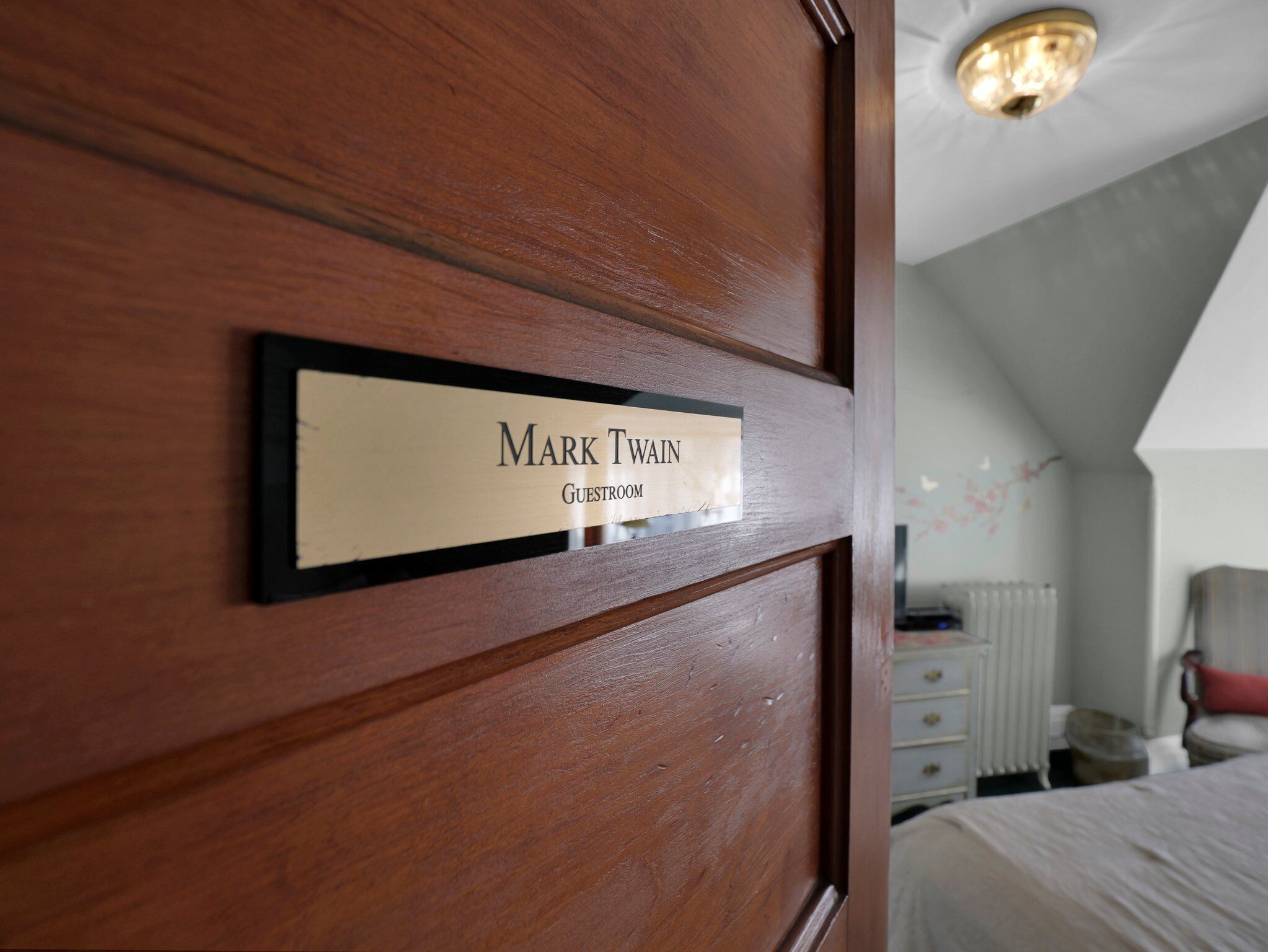 A wooden door with a nameplate reading "Mark Twain Guestroom".
