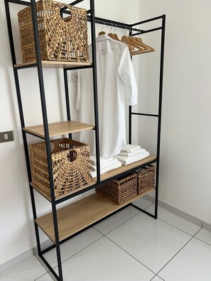 Organized storage space with a minimalist metal shelving unit, featuring multiple levels and a variety of items.