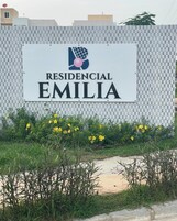 Señalización de 'Residencial Emilia' con un logotipo, sobre un muro con diseño de cuadros.