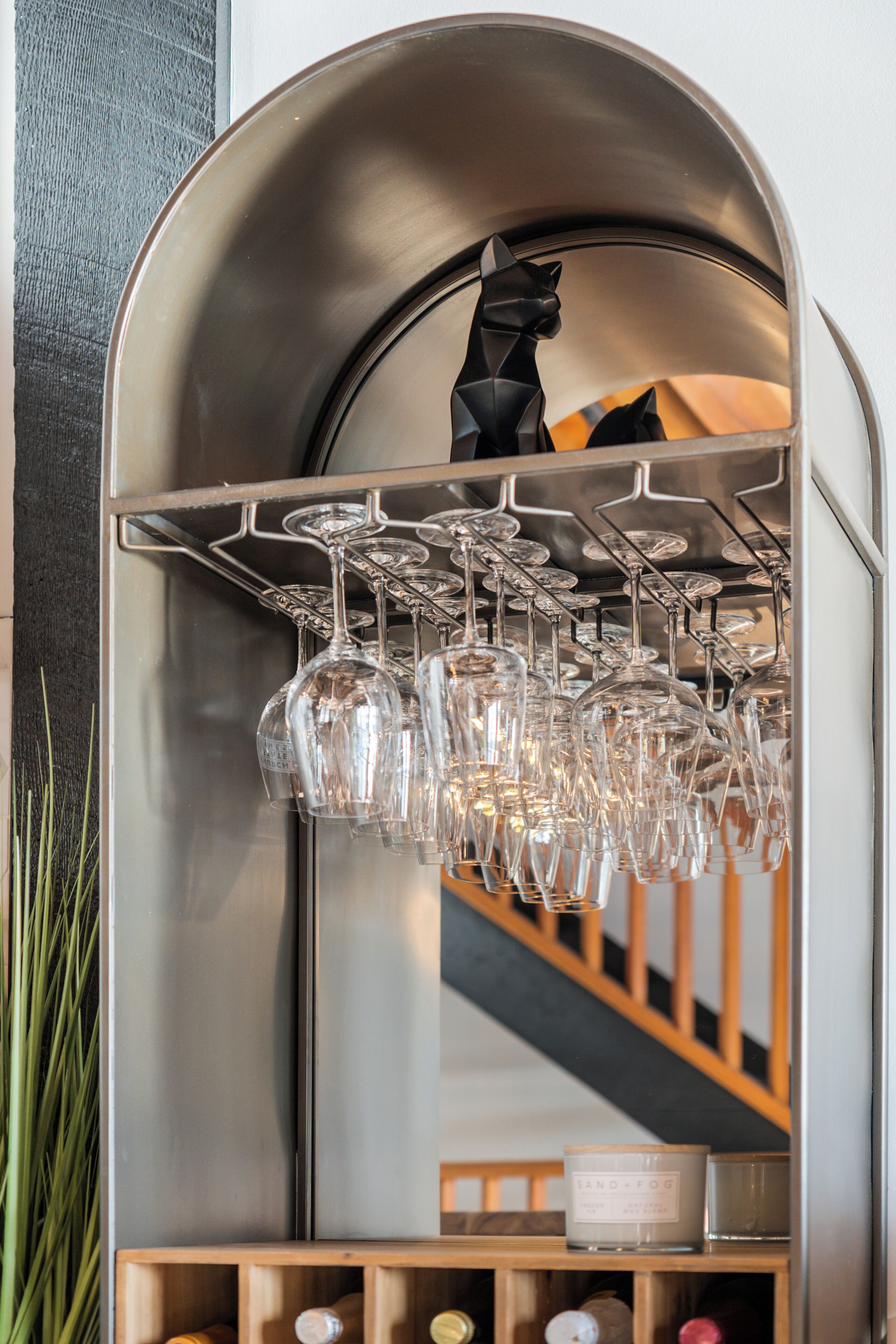 Un miroir doté d’un porte-bouteilles et de plusieurs verres à vin.