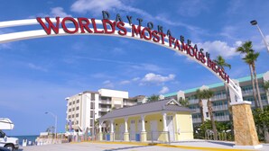 Entrada de un hotel con un cartel grande que dice "Daytona Beach World's Most Famous Beach".