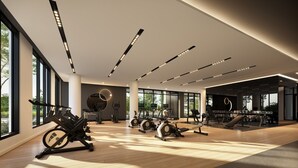 A modern gym with various exercise equipment, large windows, and a wooden floor. - Mid-century getaway (Brossard)