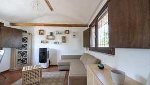 A cozy living room with a sofa, a wooden cabinet, a small table, and a TV.