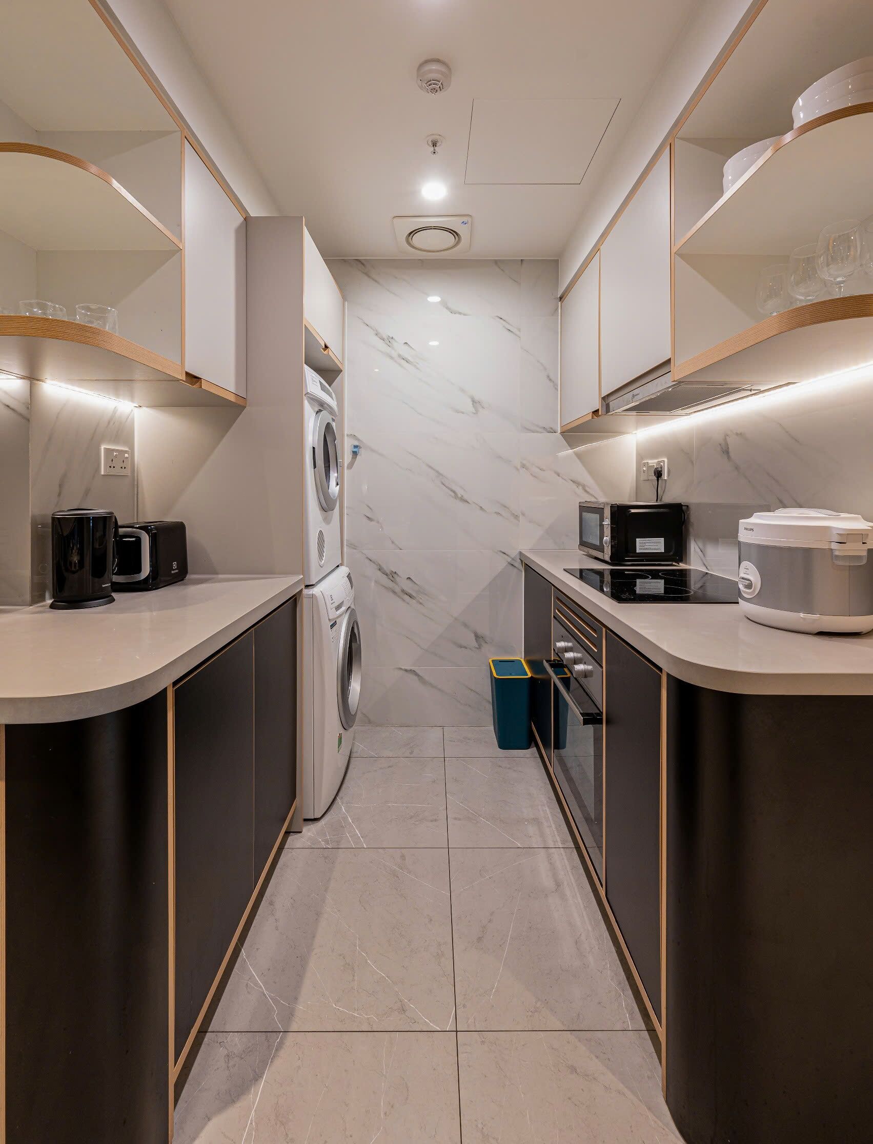 A modern kitchen with a built-in washer, microwave, and toaster.