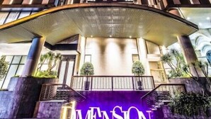 A high-rise building with a prominent entrance and the word "DIMENSION" illuminated on the ground.