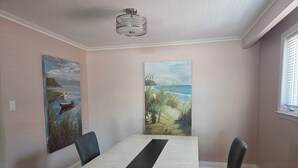 Un comedor con una mesa rectangular, dos sillas y una lámpara colgante.