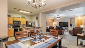 A modern apartment with a dining area, kitchen, living room, and a balcony.