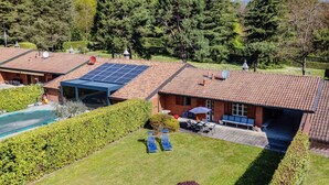 A residential property with a swimming pool, solar panels, and a well-maintained lawn. - Country House Montorfano (Capiago Intimiano)