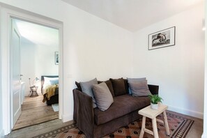A living room with a brown sofa, a small wooden table with a plant, and a framed picture on the wall. - villa Casasco - MyHomeinComo (Casasco d'Intelvi)
