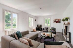 A living room with a sofa, armchair, coffee table, fireplace, and a television. - villa Casasco - MyHomeinComo (Casasco d'Intelvi)