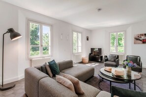 A modern living room with a sofa, armchairs, a coffee table, and a TV. - villa Casasco - MyHomeinComo (Casasco d'Intelvi)