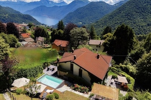 Un área residencial con piscina, rodeada de abundante vegetación y montañas al fondo.