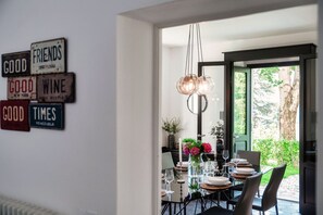 Ein Essbereich mit Tisch für vier Personen, einer Kandelaber und einer Wand mit Oldtimer-Kennzeichen.