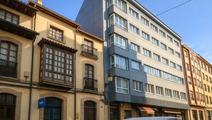 Een meerlaags gebouw met een combinatie van traditionele en moderne architectuur, met balkons en grote ramen.