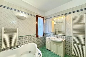 A bathroom with a freestanding bathtub, a sink, and a mirror. - Ca delle Rose 8 - Carraro Immobiliare Jesolo (Lido di Jesolo)