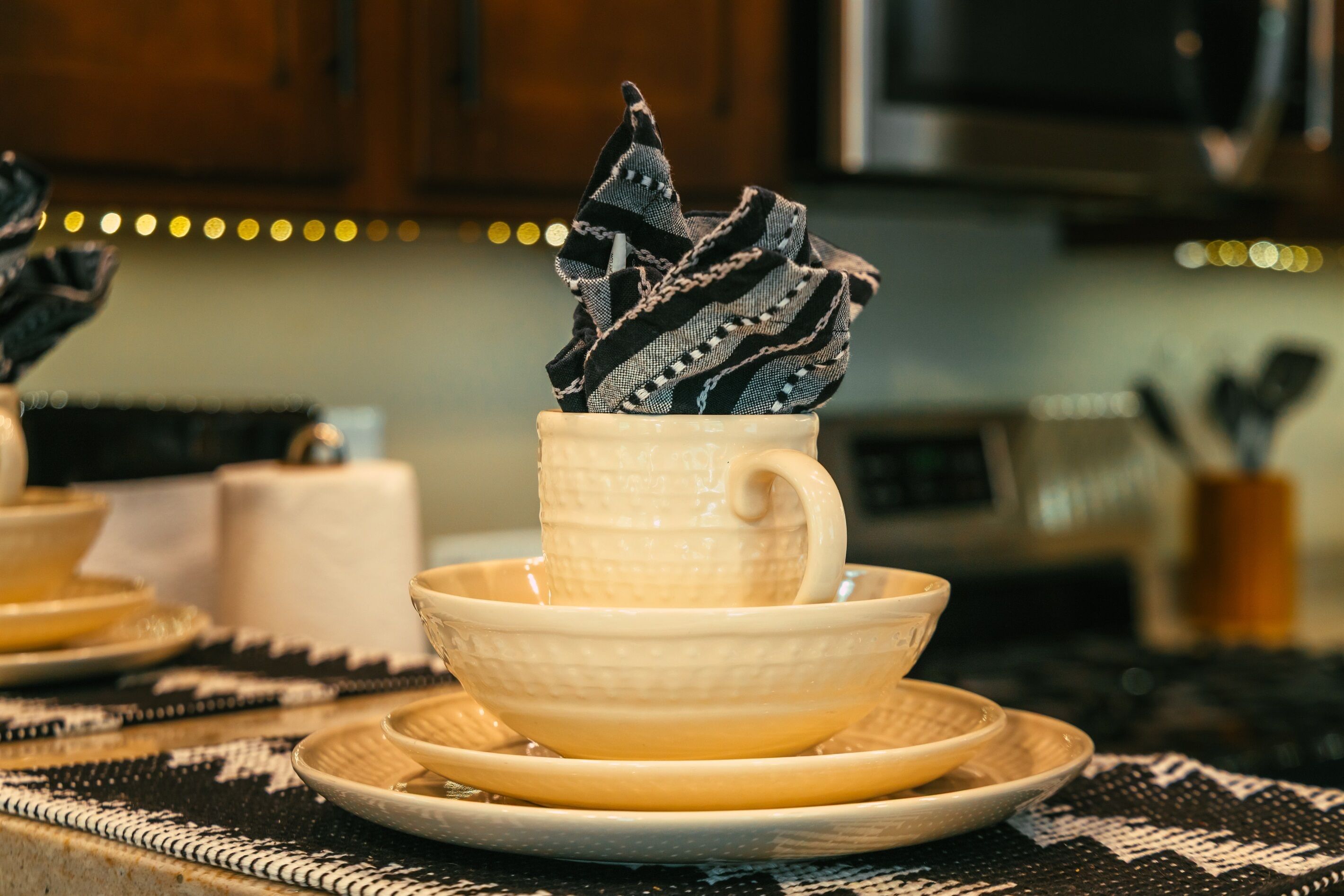 Une cuisine avec une tasse et une soucoupe blanches posées sur un set de table en fibres tressées.