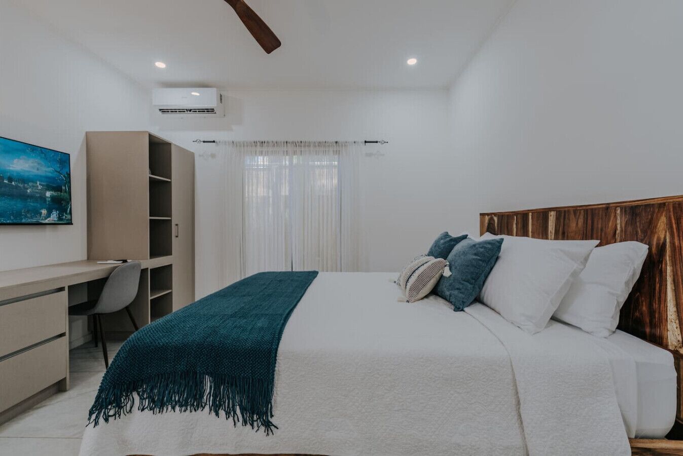 Ein Schlafzimmer mit Bett, Schreibtisch und Kleiderschrank.