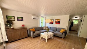 Una sala de estar acogedora con un sofá, una mesa de centro y un aparador.