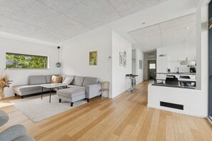 Una sala de estar moderna con un sofá, una mesa de centro y vistas al exterior.