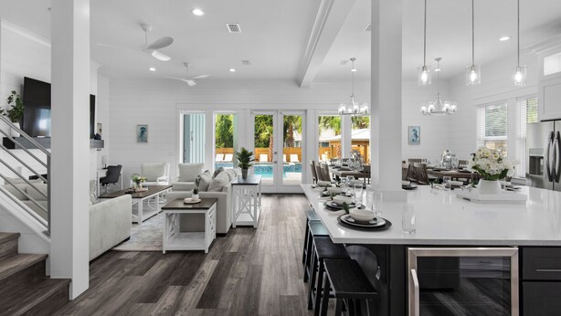 Een ruime keuken met een groot eiland, moderne apparatuur en hanglampen.