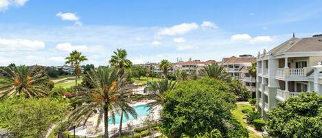 Un resort con piscina, exuberante vegetación y varios edificios con balcones.