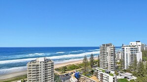 A coastal view with high-rise buildings, a beach, and a clear blue sky. - Stunning Ocean View 3BR near Broadbeach | Parking (Surfers Paradise)