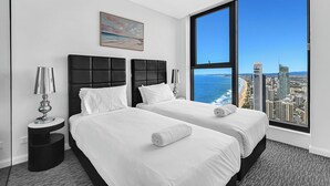 A hotel room with two beds, a large window with a city view, and a painting on the wall. - Ocean and City View | 3BR Beachside Retreat Level 63 (Surfers Paradise)