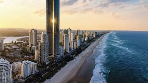 A coastal cityscape with high-rise buildings, a beach, and the ocean. - Ocean and City View | 3BR Beachside Retreat Level 63 (Surfers Paradise)