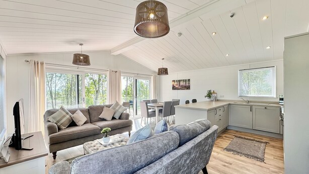 Una sala de estar moderna con un sofá, una mesa de comedor y una zona de cocina.