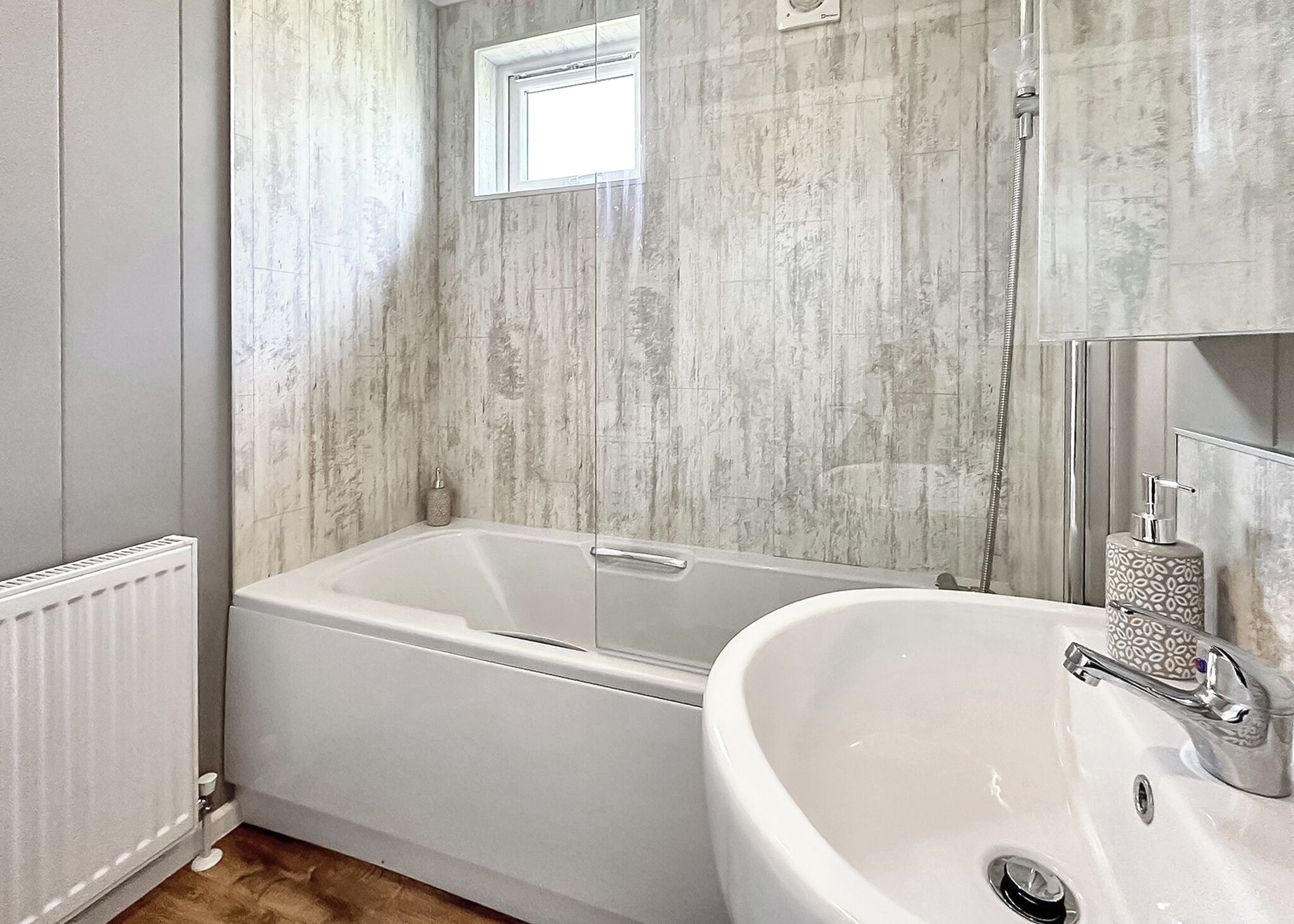 Un baño con bañera, lavamanos y ventana.
