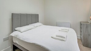 A bedroom with a bed, a radiator, a dresser, and a mirror. - Beacon Fell Cottage 2 (Longridge, Ribble Valley)