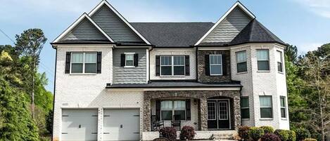 Stunning two-story residence with a symmetrical facade, featuring a prominent front entrance and well-manicured grounds.