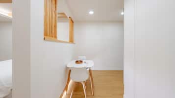 Simple, functional space with a dining table, woven basket, and natural textures.
